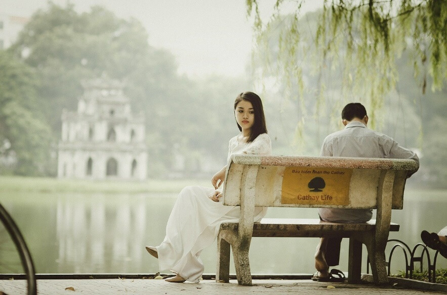 Frau und Mann sitzen am Teich